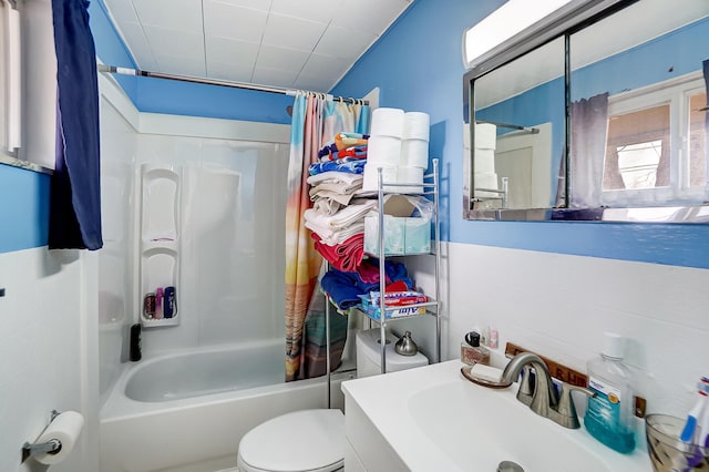 full bathroom featuring a sink, shower / bathtub combination with curtain, and toilet