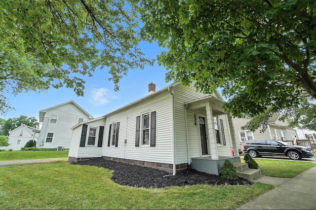 224 Monroe St, Delphos, OH 45833 - view of home's exterior featuring a chimney and a lawn