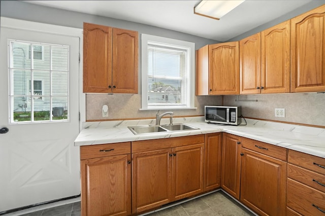 224 Monroe St, Delphos, OH 45833 - kitchen with stainless steel microwave, light stone countertops, light tile patterned floors, and brown cabinetry