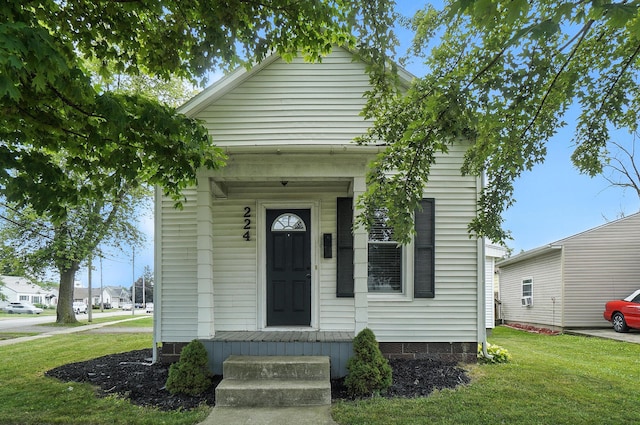 224 Monroe St, Delphos, OH 45833 - shotgun-style home featuring a front yard and covered porch