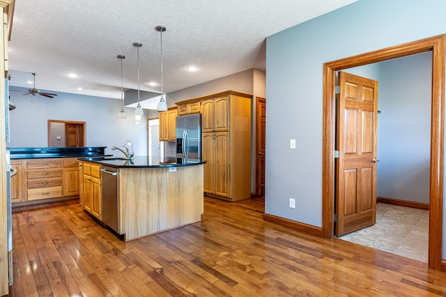 11370 Crottinger Rd, Plain City, OH 43064 - kitchen featuring stainless steel appliances, dark countertops, hardwood / wood-style floors, a sink, and a textured ceiling