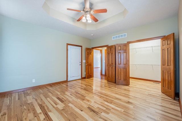 11370 Crottinger Rd, Plain City, OH 43064 - unfurnished bedroom featuring light wood-style flooring, a raised ceiling, baseboards, and a ceiling fan