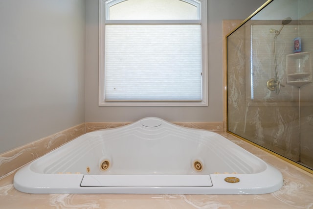 bathroom with a shower and a whirlpool tub