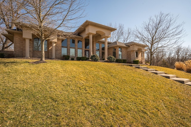 view of front of home with a front yard and brick siding