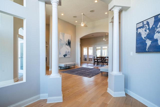 corridor featuring recessed lighting, light wood-style floors, baseboards, and ornate columns