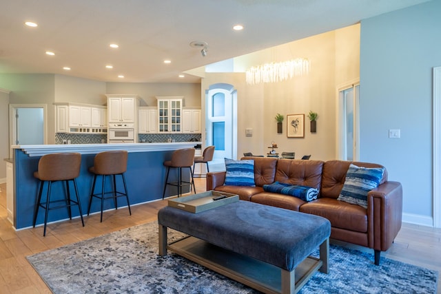 living area with recessed lighting, light wood-type flooring, and baseboards