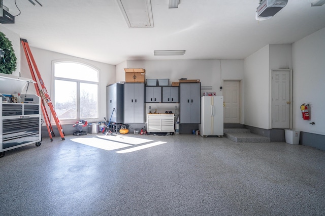 garage with a garage door opener and freestanding refrigerator