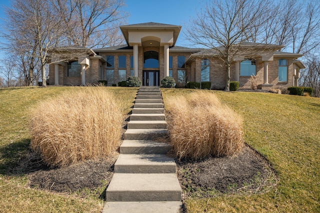 prairie-style home with a front yard and brick siding