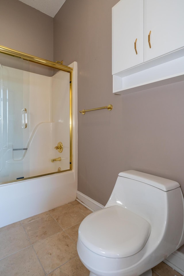 full bathroom featuring tile patterned floors, baseboards, bath / shower combo with glass door, and toilet