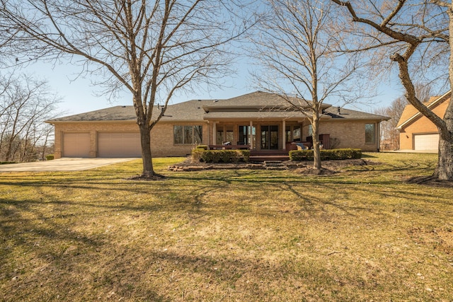 view of front of house with a front yard, driveway, a porch, a garage, and brick siding