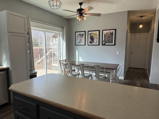 dining space featuring dark hardwood / wood-style flooring, ceiling fan, and a textured ceiling