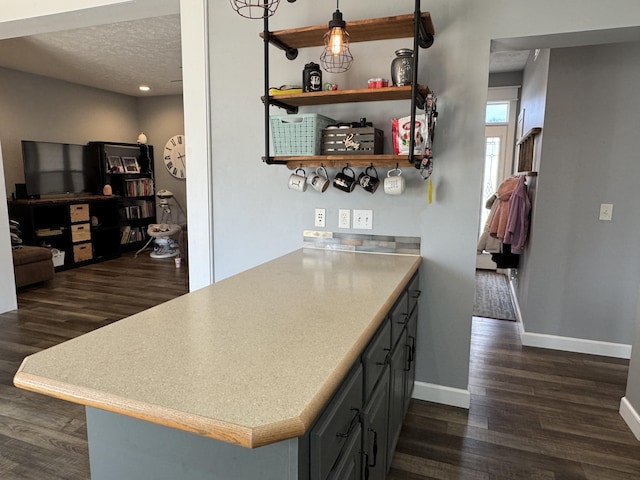 kitchen featuring dark wood-type flooring, a textured ceiling, and kitchen peninsula