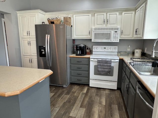 kitchen with white cabinetry, appliances with stainless steel finishes, gray cabinets, and dark wood-type flooring