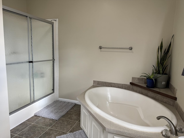 bathroom with independent shower and bath and tile patterned floors