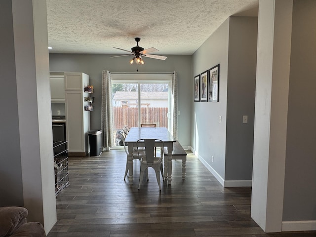 dining space featuring dark hardwood / wood-style floors, a textured ceiling, and ceiling fan