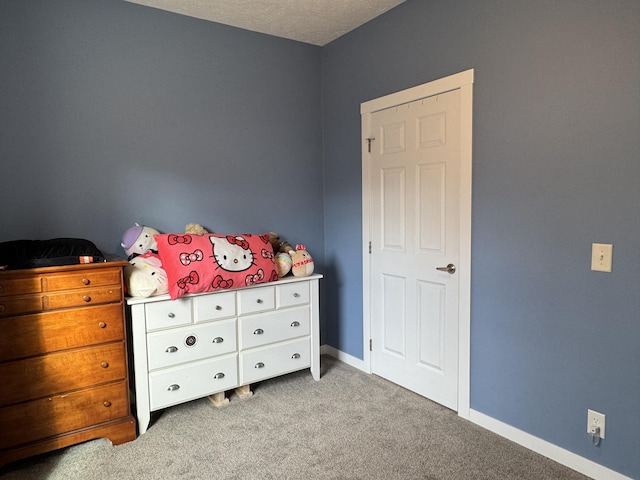 bedroom featuring light carpet and a textured ceiling