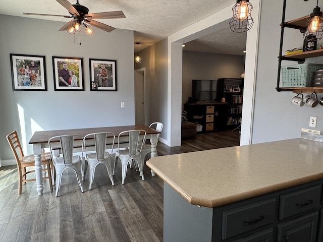 dining room with dark wood-type flooring, ceiling fan, and a textured ceiling