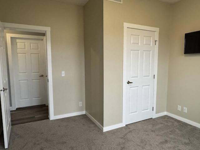 unfurnished bedroom with dark carpet