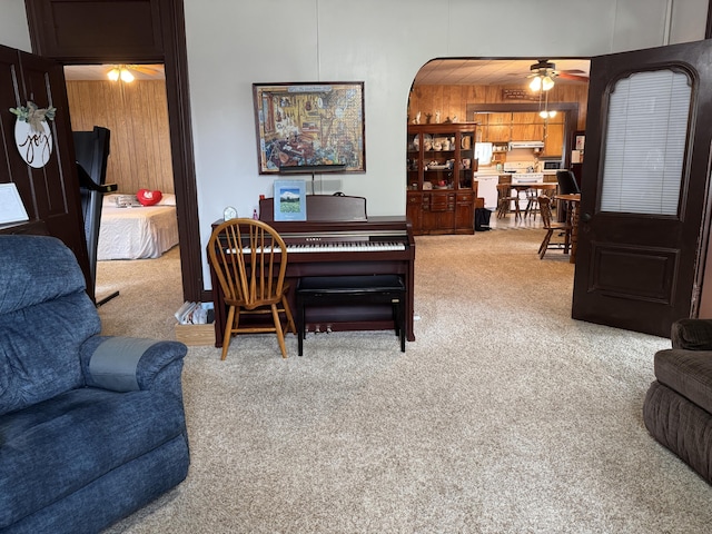 210 E Second St, Rockford, OH 45882 - living area with a ceiling fan, carpet flooring, wood walls, and arched walkways