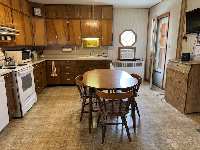 210 E Second St, Rockford, OH 45882 - kitchen with white appliances, light flooring, radiator, under cabinet range hood, and light countertops