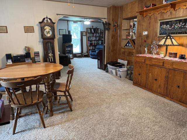210 E Second St, Rockford, OH 45882 - carpeted dining space featuring wood walls, ceiling fan, and arched walkways