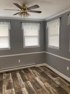 4173 Navajo Trl, Jamestown, OH 45335 - unfurnished room with crown molding, wood finished floors, a baseboard radiator, and ceiling fan