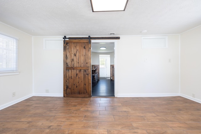 11068 Big Bear Path, Lakeview, OH 43331 - empty room with wood finished floors, a textured ceiling, a barn door, baseboards, and crown molding