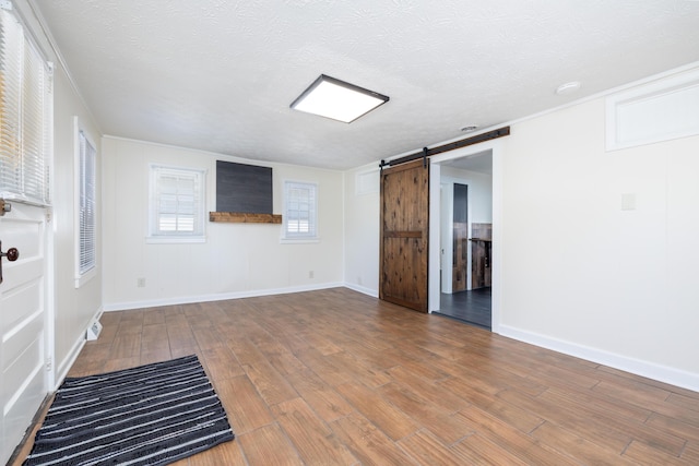 11068 Big Bear Path, Lakeview, OH 43331 - unfurnished living room featuring a barn door, wood finished floors, a textured ceiling, and baseboards