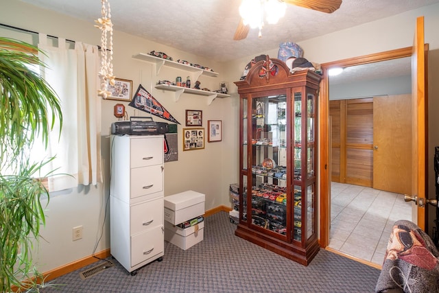 interior space with ceiling fan, light colored carpet, and a textured ceiling