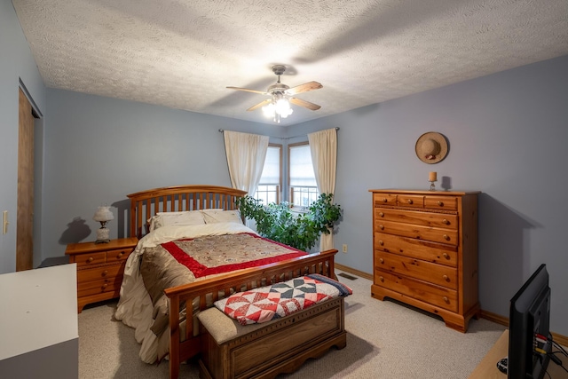 bedroom with ceiling fan, light colored carpet, a textured ceiling, and a closet