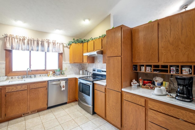 kitchen featuring lofted ceiling, appliances with stainless steel finishes, sink, and backsplash