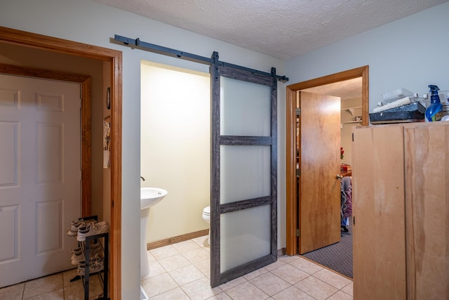 bathroom featuring tile patterned floors, toilet, and a textured ceiling