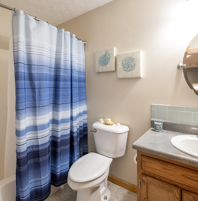 bathroom with vanity, toilet, tile patterned flooring, and a textured ceiling