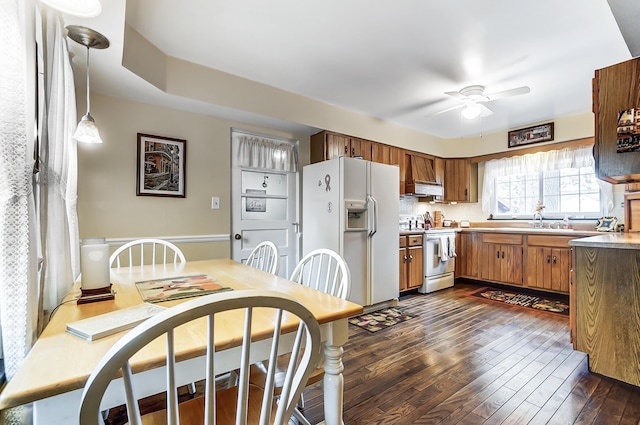 407 N Broadmoor Blvd, Springfield, OH 45504 - kitchen featuring white appliances, brown cabinetry, dark wood-style floors, a ceiling fan, and wainscoting