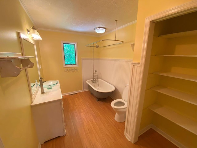 2700 Myeerah Trl, West Liberty, OH 43357 - bathroom with a freestanding bath, a textured ceiling, crown molding, wood finished floors, and double vanity