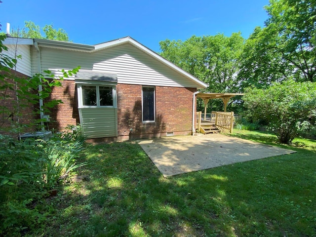2700 Myeerah Trl, West Liberty, OH 43357 - rear view of house with brick siding, a patio area, a yard, and a wooden deck