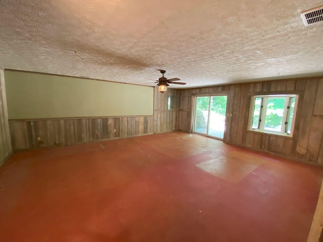 2700 Myeerah Trl, West Liberty, OH 43357 - unfurnished room with a textured ceiling, a ceiling fan, and wooden walls
