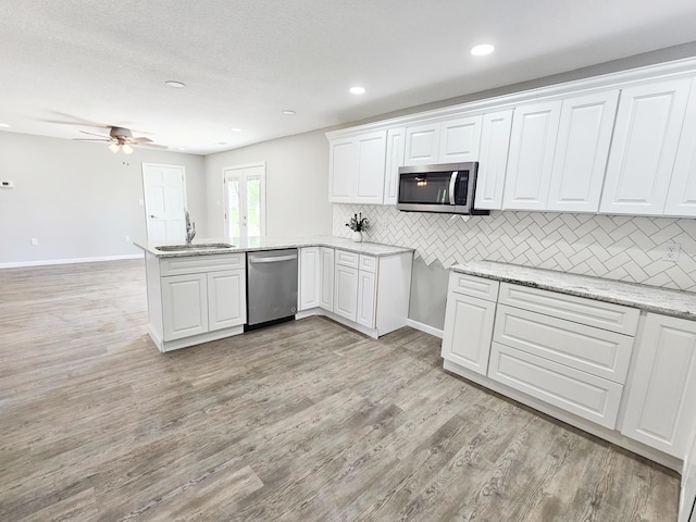 5412 Lock Two Rd, New Bremen, OH 45869 - kitchen with appliances with stainless steel finishes, a sink, a peninsula, white cabinetry, and backsplash