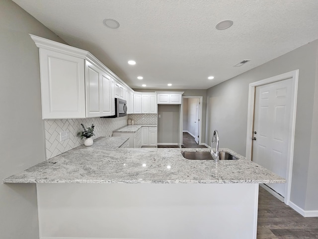 5412 Lock Two Rd, New Bremen, OH 45869 - kitchen with white cabinets, tasteful backsplash, light stone counters, a sink, and dark wood finished floors