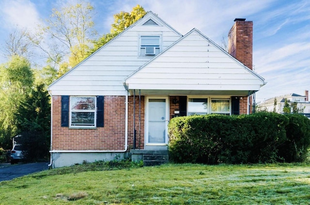 bungalow-style home featuring a chimney, a front lawn, and brick siding