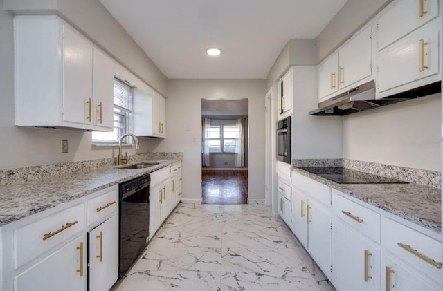 kitchen with marble finish floor, white cabinets, a sink, under cabinet range hood, and black appliances