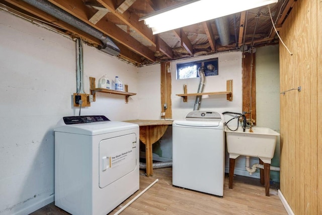 laundry area featuring a sink, laundry area, light wood-type flooring, and washing machine and dryer