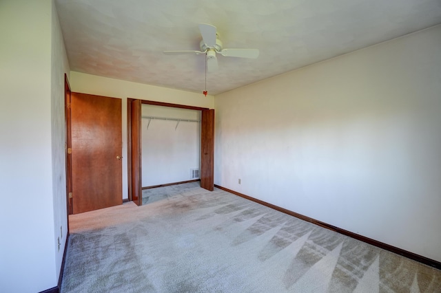 unfurnished bedroom with a closet, carpet flooring, baseboards, visible vents, and ceiling fan