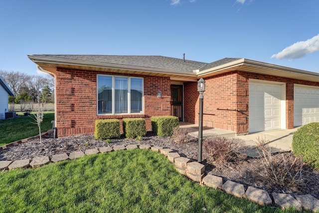 ranch-style house with an attached garage, a front yard, brick siding, driveway, and cooling unit