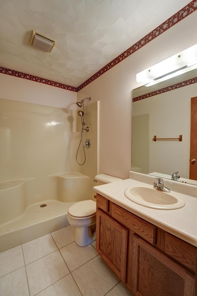 bathroom with toilet, vanity, tile patterned flooring, walk in shower, and visible vents