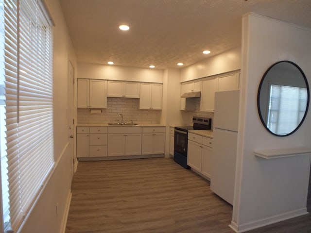 kitchen with sink, black / electric stove, white refrigerator, dark hardwood / wood-style floors, and white cabinets