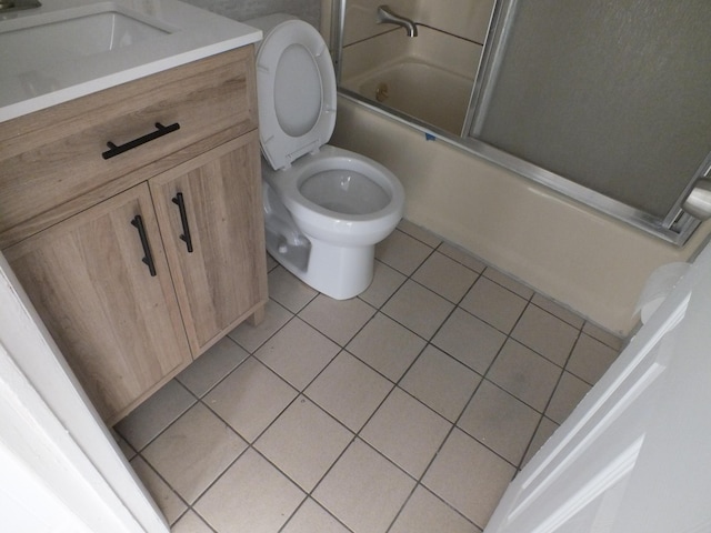 full bathroom featuring bath / shower combo with glass door, tile patterned floors, toilet, and vanity