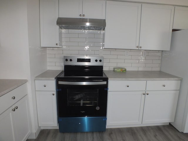 kitchen with hardwood / wood-style flooring, refrigerator, white cabinetry, electric range, and decorative backsplash