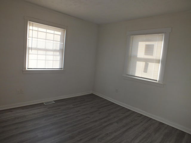 unfurnished room with dark hardwood / wood-style flooring