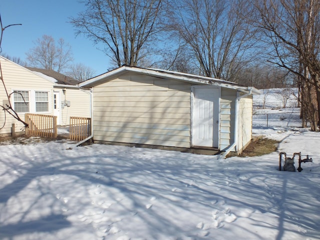 view of snowy exterior with an outdoor structure